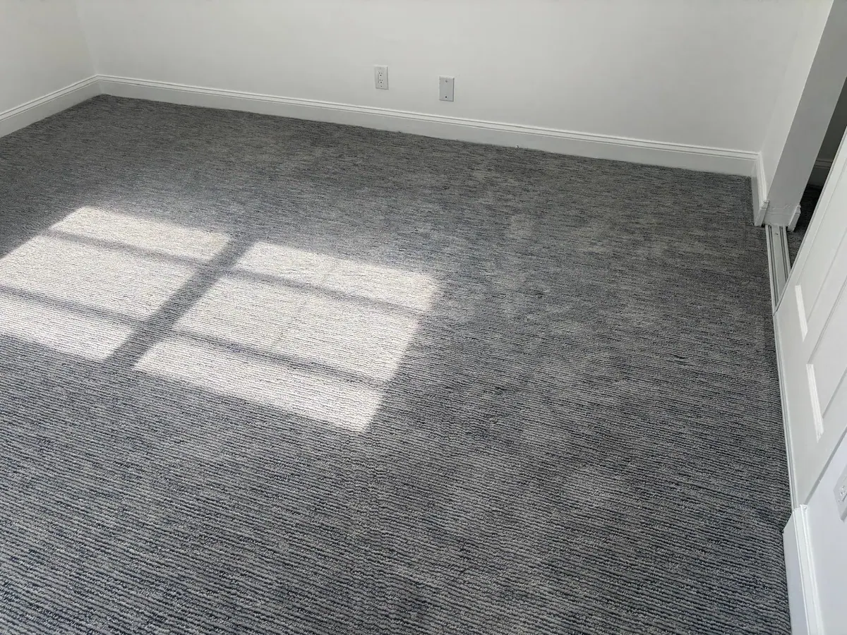 New gray carpet installation in a bedroom by JC General Painting in South Florida