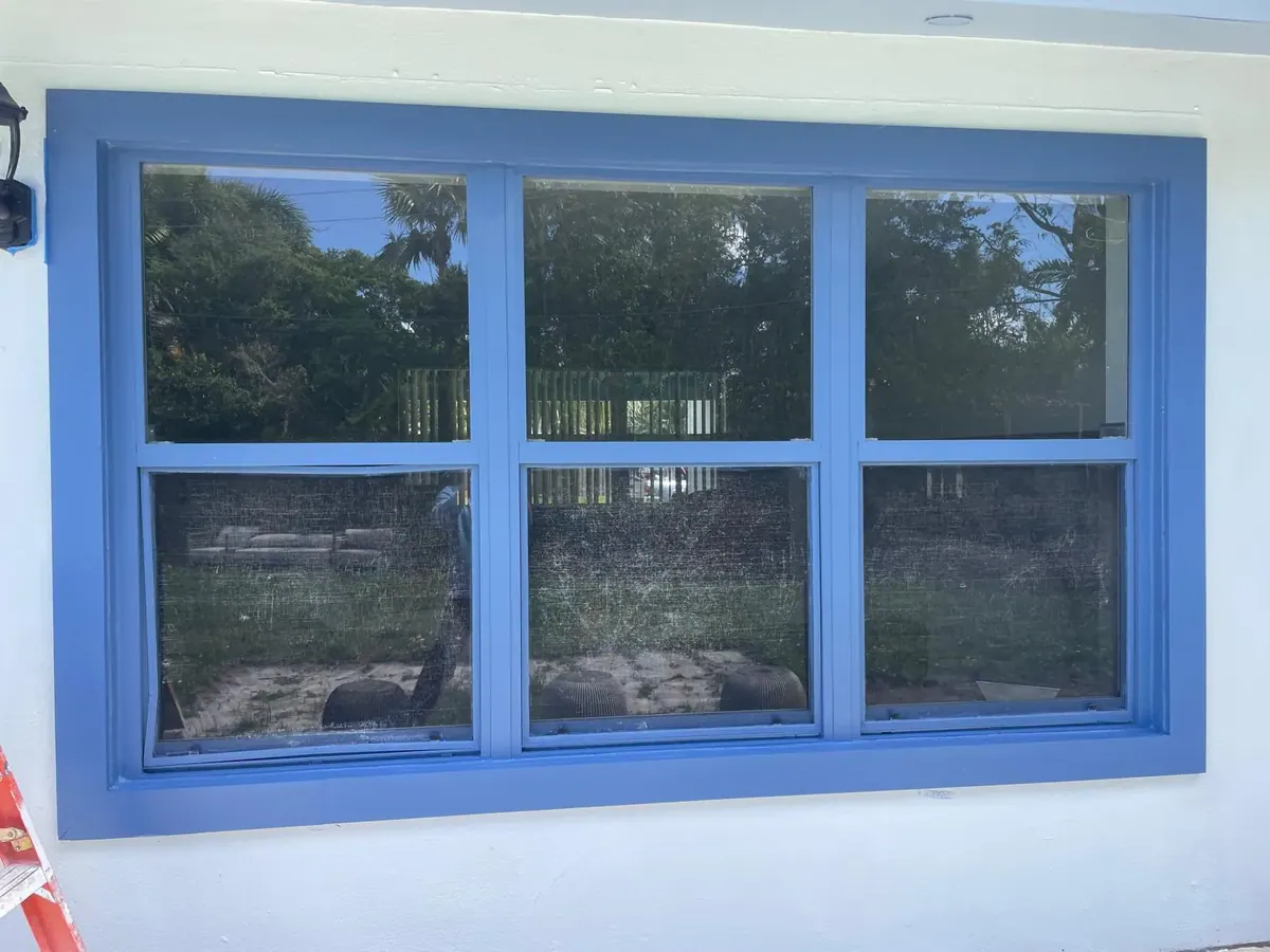 Exterior window frame and trim painted bright blue by JC General Painting in South Florida