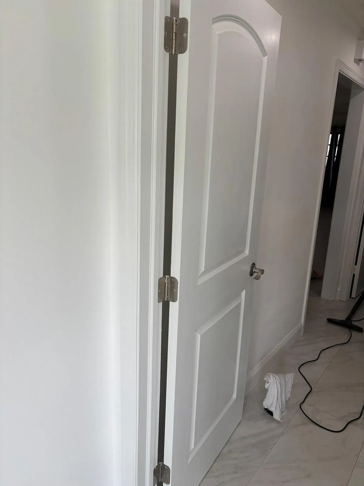 New white arched two-panel interior door installation by JC General Painting in South Florida