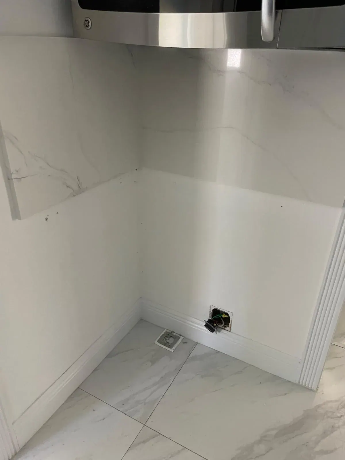 Marble tile wall and white baseboard in a kitchen alcove by JC General Painting in South Florida