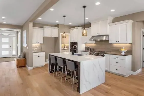 Modern kitchen remodel with white shaker cabinets and a marble waterfall island by JC General Painting in South Florida