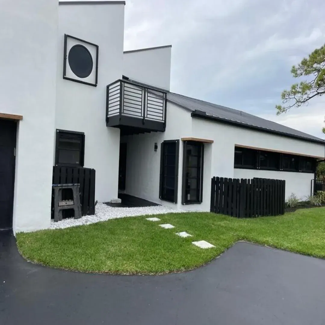 Contemporary white-and-black home exterior by JC General Painting in South Florida