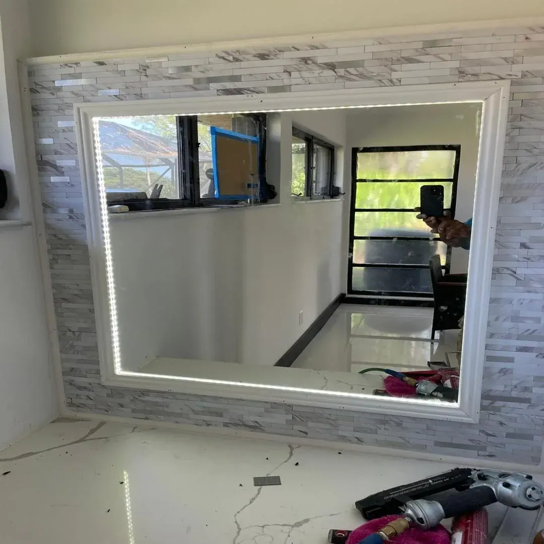 Backlit LED mirror and stone tile bathroom wall by JC General Painting in South Florida