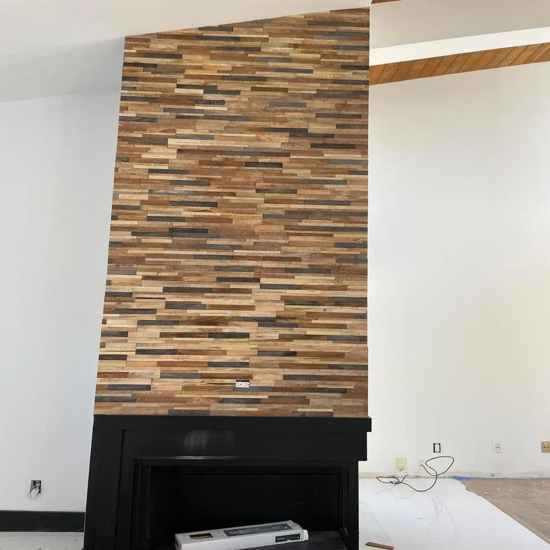 Stacked stone and wood feature wall with fireplace by JC General Painting in South Florida