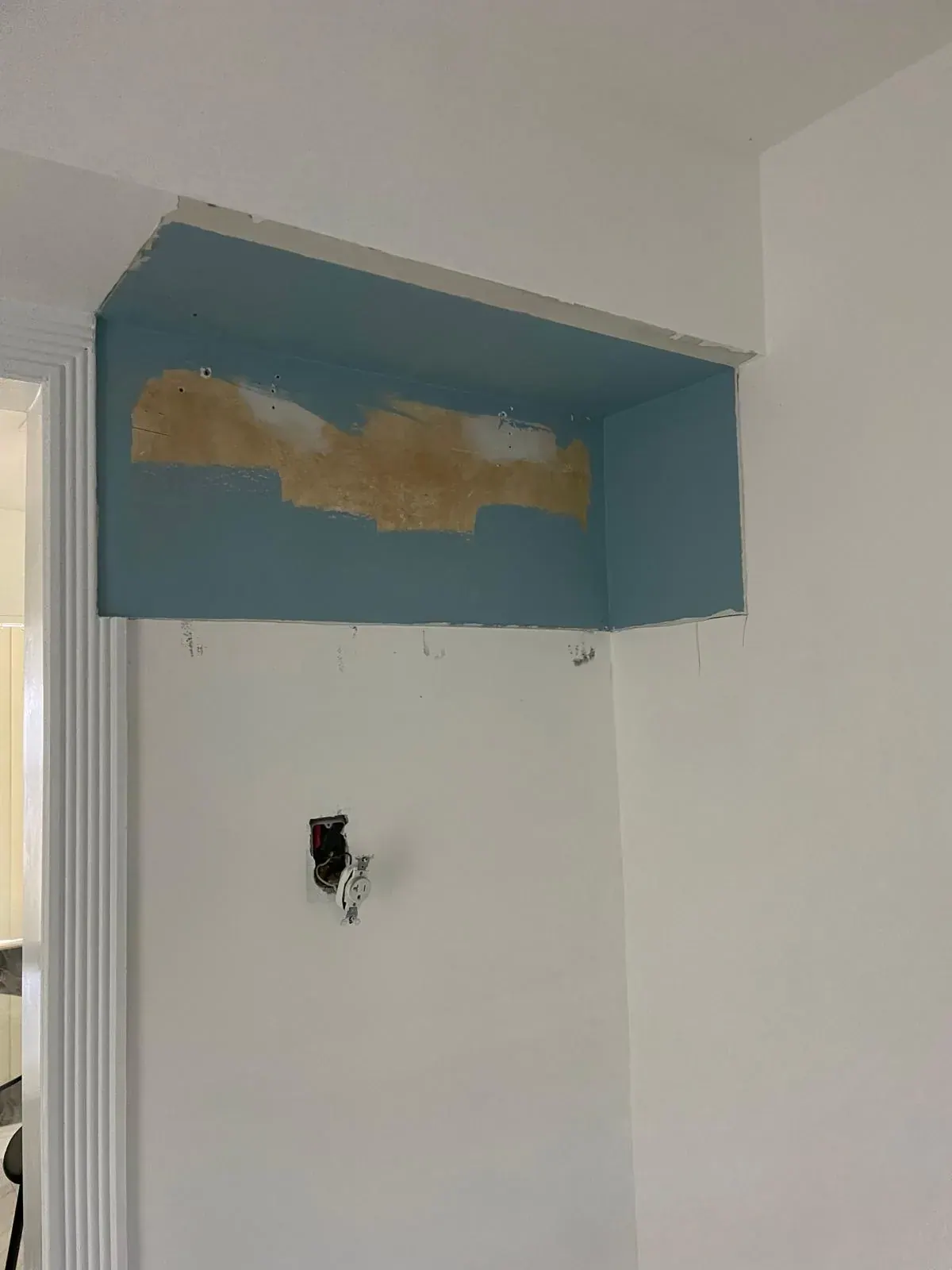 Removing a bulkhead soffit and patching drywall during a kitchen remodel by JC General Painting in South Florida